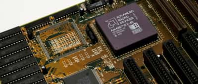 A macro shot of an Advanced Micro Devices (AMD) microchip installed on a green motherboard.