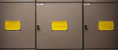 Blank yellow labels sit on the doors of steel filing cabinets.
