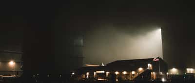 An illuminated industrial facility at a space exploration center at night.