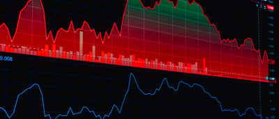A dark digital display showing a prominent red financial chart indicating a stock market decline.