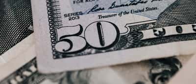 A close-up view of a U.S. fifty-dollar bill focusing on the title and signature of the Treasurer of the United States.