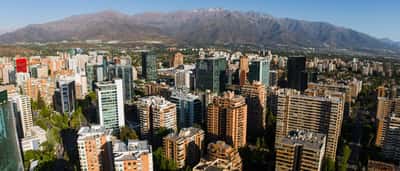 Aerial view of the modern financial district skyline in Santiago, Chile, with the Andes Mountains in the background.