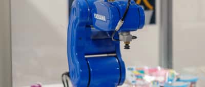 A blue Yaskawa industrial robot arm on display.