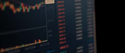 A close-up of a computer screen displaying dynamic financial market data and trading charts.