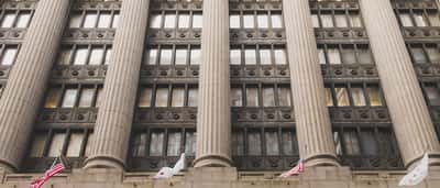A low-angle view of a grand neoclassical building facade featuring large traditional stone columns.