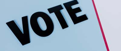 The word 'VOTE' is displayed in bold text against a simple, minimal background.