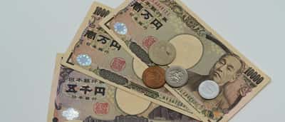 A collection of Japanese yen banknotes and coins arranged on a flat surface.