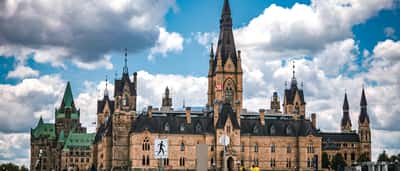 The iconic architecture of Parliament Hill in Ottawa, Canada, standing against a vibrant sky.