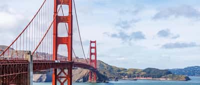 A clear daytime view of the red towers and suspension cables of the Golden Gate Bridge spanning San Francisco Bay.