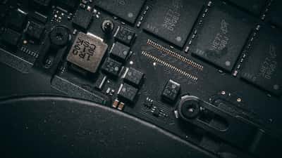 A close-up view of microchips and electronic components on a dark computer circuit board.