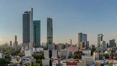 The modern skyline of Mexico City's financial district rises against a clear sky.