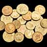 A collection of various gold investment coins resting against a black background.
