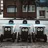 Autonomous delivery robots line up on an urban street, representing the use of artificial intelligence in modern retail and logistics.