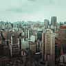 A dense urban skyline with modern high-rises and busy elevated highways in São Paulo, Brazil.