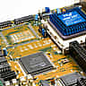 A close-up view of an Intel microchip and electronic components on a bright computer motherboard.