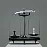 A black and a white chess piece sitting on opposite sides of an unbalanced metal scale.