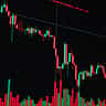 A digital financial chart displaying a sharp downward trend with red candlestick patterns against a dark grid.