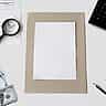 A blank piece of white paper sits on a desk surrounded by stock charts, a magnifying glass, a calculator, and hundred-dollar bills.