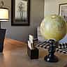 A world globe, a laptop, and wooden calendar blocks sit on a desk in a warm, modern office setting.