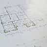 A close-up view of an architectural blueprint and floor plan with highlighted sections.