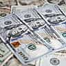 A detailed close-up of a scattered arrangement of United States dollar banknotes.