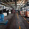 A wide view of a quiet, orderly factory floor lined with heavy machinery and crates of parts.