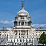 The United States Capitol building stands under a clear blue sky.