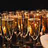 A row of sparkling champagne glasses prepared for a celebratory corporate event.