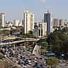 An aerial view of the urban skyline and a bustling expressway in São Paulo, Brazil.