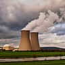 Dark, stormy clouds gather over the cooling towers of a nuclear power plant.