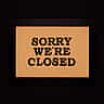 A framed sign reading 'Sorry we're closed' against a dark background.