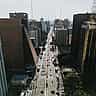 An aerial daytime view of Paulista Avenue in São Paulo, Brazil, showing heavy traffic and modern corporate skyscrapers.