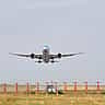 A large passenger airplane lifts off the runway into a clear sky.