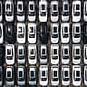 An aerial view shows hundreds of new cars neatly arranged in rows in a massive factory parking lot.