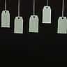 Multiple blank cardboard price tags hang from strings against a dark background.