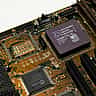 A macro shot of an Advanced Micro Devices (AMD) microchip installed on a green motherboard.