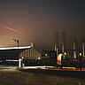 Silhouetted Starship rockets stand at the SpaceX Starbase facility under a foggy night sky.