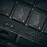 A close-up view of black computer memory chips mounted on a dark circuit board.