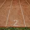 A vibrant red running track with bright white lane markers.
