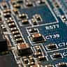 A macro view of an electronic circuit board with intricate metallic traces and components.