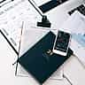 A high-angle view of a stock trading desk featuring printed financial charts and a smartphone displaying market trends.