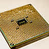A macro view of the golden pins on the underside of a semiconductor microprocessor.