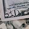 A close-up view of a U.S. fifty-dollar bill focusing on the title and signature of the Treasurer of the United States.