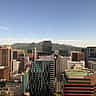 A bright, modern view of the Seoul skyline and business district under a clear blue sky.