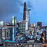 A panoramic view of the modern Ho Chi Minh City skyline with illuminated skyscrapers at dusk.