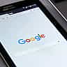 A close-up view of a tablet screen displaying the Google search engine homepage.