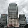 The Citi and HSBC logos top neighboring skyscrapers in London's Canary Wharf under a cloudy sky.