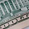 A macro photograph of a ten-dollar banknote revealing the engraved U.S. Treasury building and the words U.S. TREASURY.