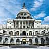 The exterior of the United States Capitol building viewed from the front on a sunny day.