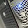 Close-up of a modern data center server rack glowing with blue LED lights.